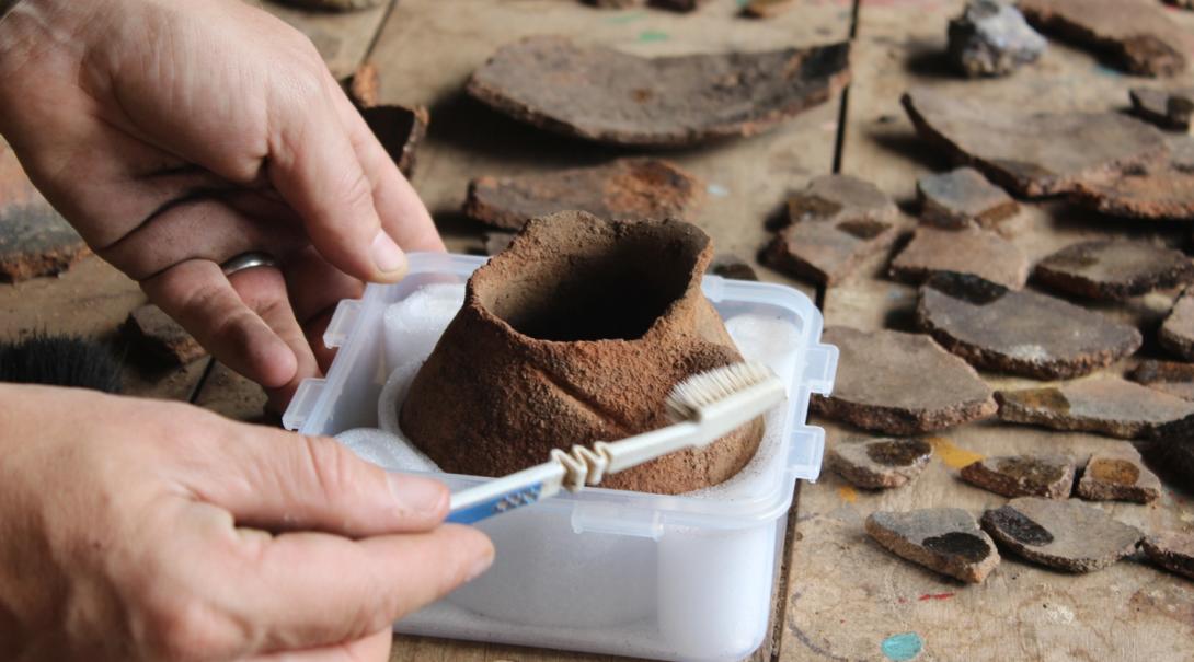 考古学ボランティアがペルーの遺跡発掘現場で発見された陶器の解明に励む ペールの考古学ボランティアが発掘物の登録作業に取り組む